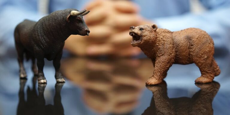 bull bear figurines in front of folded hands gID 7