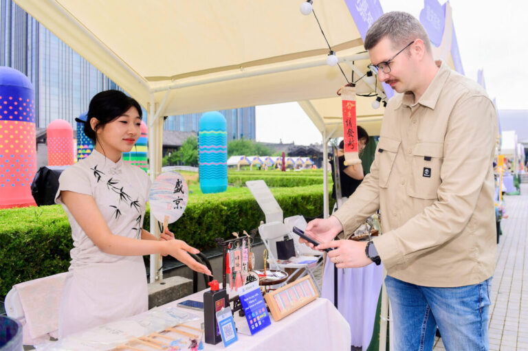 An international visitor paying with Alipay at a souvenir store in China e1729814200679